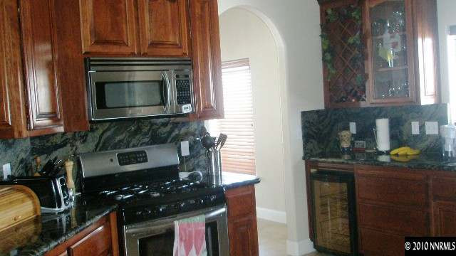 1622 Ray Court Fernley, NV 89408 - Photo 5 of 9 a kitchen with granite countertop stainless steel appliances a stove a sink and a microwave