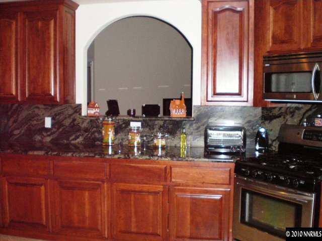 1622 Ray Court Fernley, NV 89408 - Photo 6 of 9 a kitchen with stainless steel appliances granite countertop a stove a sink and a microwave