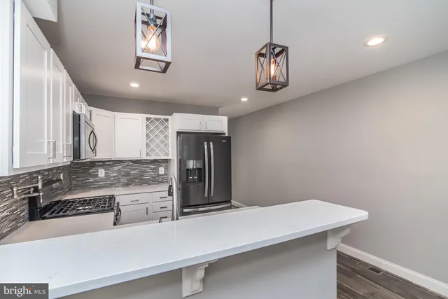 a view of a kitchen with a sink dishwasher a refrigerator and wooden floor