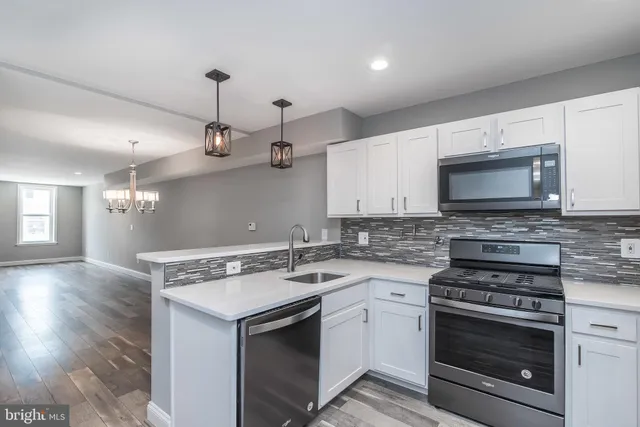 a kitchen with stainless steel appliances granite countertop a sink a stove and refrigerator