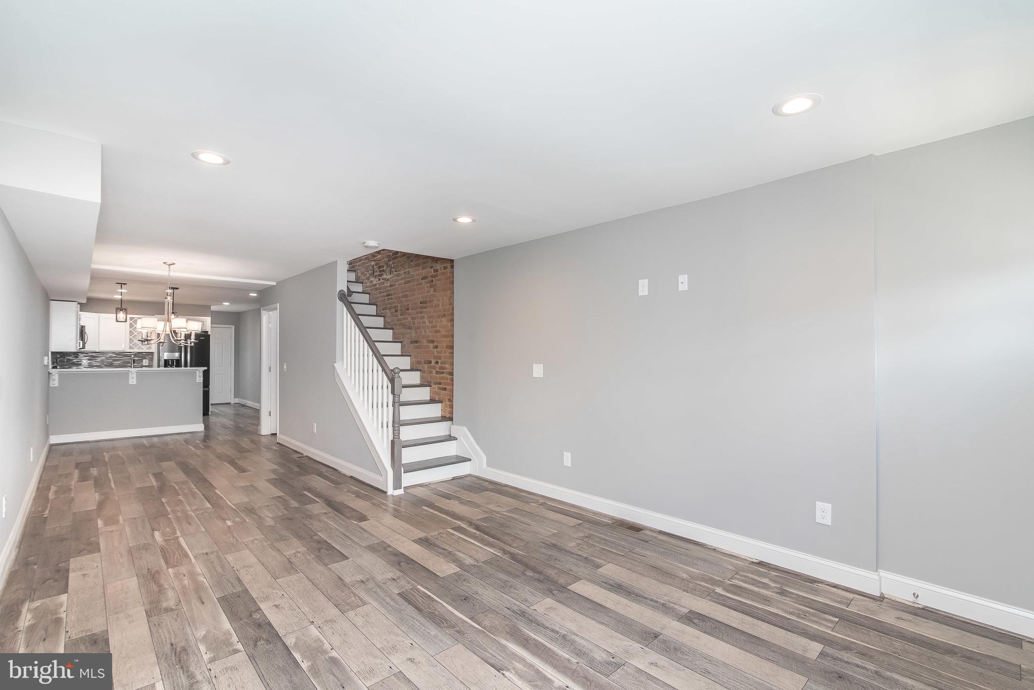 704 East Fort Avenue Baltimore, MD 21230 - Photo 26 of 58 a view of an empty room with wooden floor kitchen view and a window