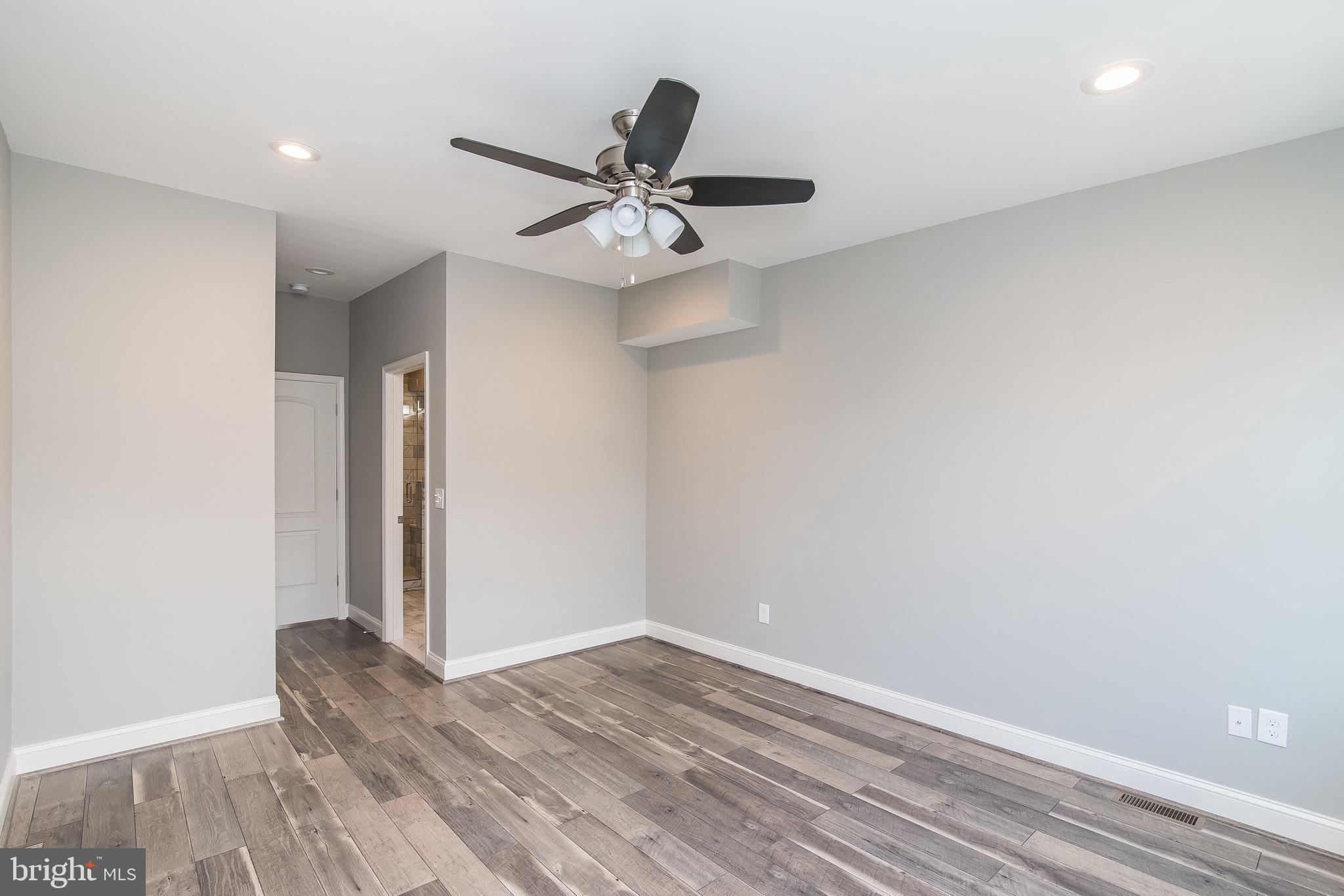 704 East Fort Avenue Baltimore, MD 21230 - Photo 34 of 58 an empty room with wooden floor a ceiling fan and windows