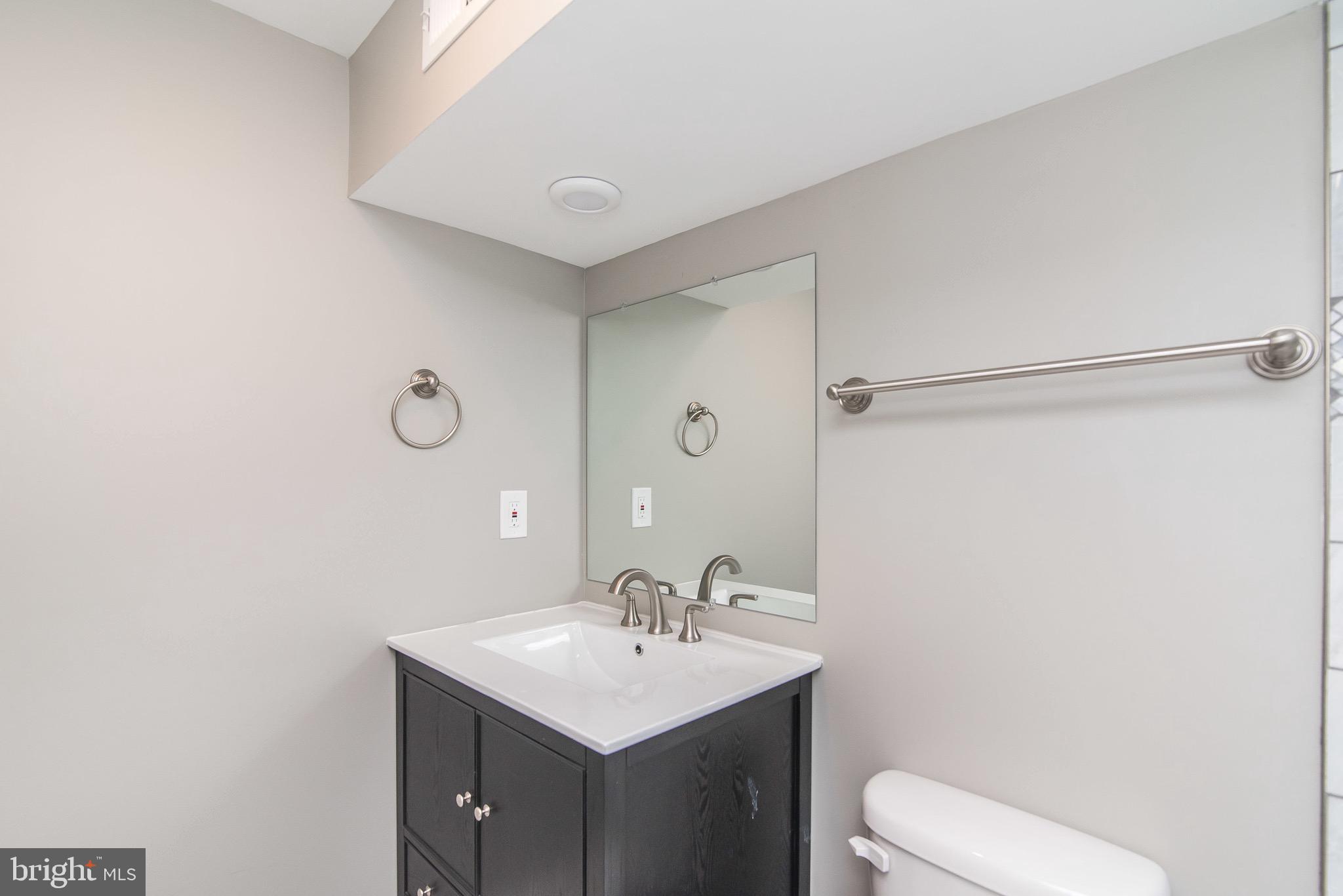 704 East Fort Avenue Baltimore, MD 21230 - Photo 9 of 58 a bathroom with a toilet a sink a mirror and vanity