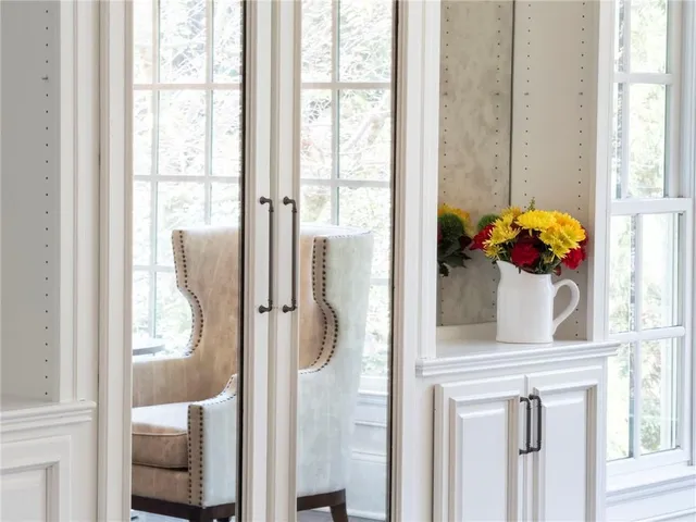 a bed sitting in a spacious bedroom next to a window and wooden floor