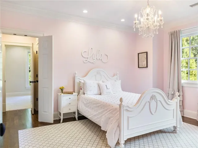 a view of staircase with lots of frames on wall and wooden floor