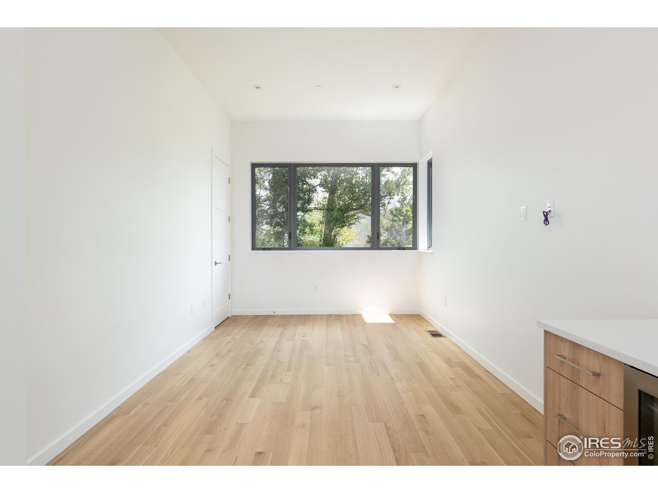 2130 Folsom Street Boulder, CO 80302 - Photo 35 of 40 a view of an empty room with wooden floor and a window