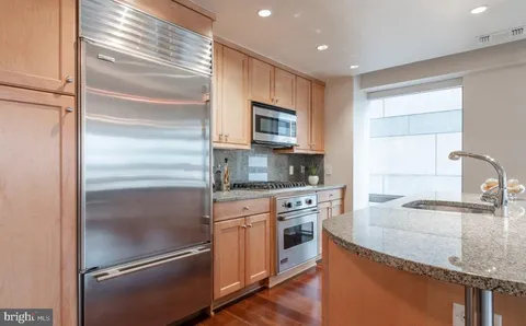 a kitchen with granite countertop stainless steel appliances and wooden cabinets