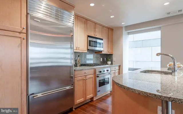 a kitchen with granite countertop stainless steel appliances and wooden cabinets