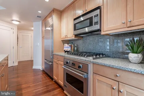 a kitchen with granite countertop a sink stove and microwave