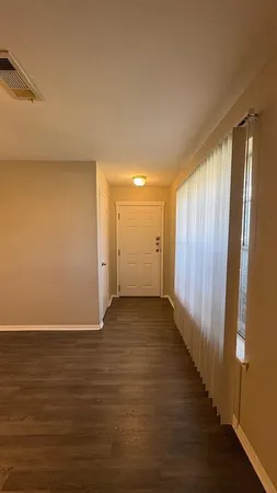 a view of a room with wooden floor and lamp