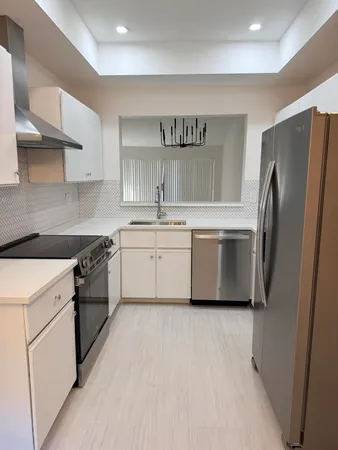 a kitchen with stainless steel appliances a sink cabinets and a refrigerator