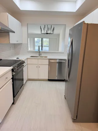 a kitchen with stainless steel appliances granite countertop a refrigerator sink and stove
