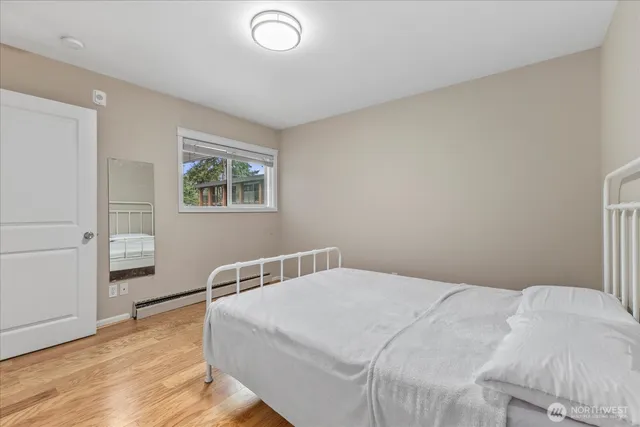a bedroom with a bed and wooden floor