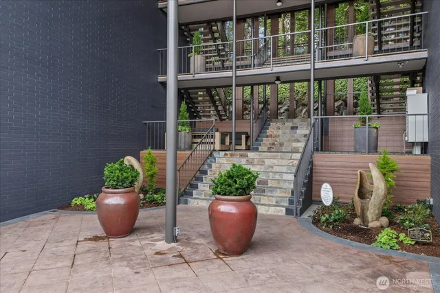 a view of a balcony with chairs and potted plants
