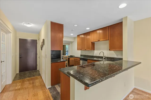a kitchen with stainless steel appliances granite countertop a sink and a refrigerator