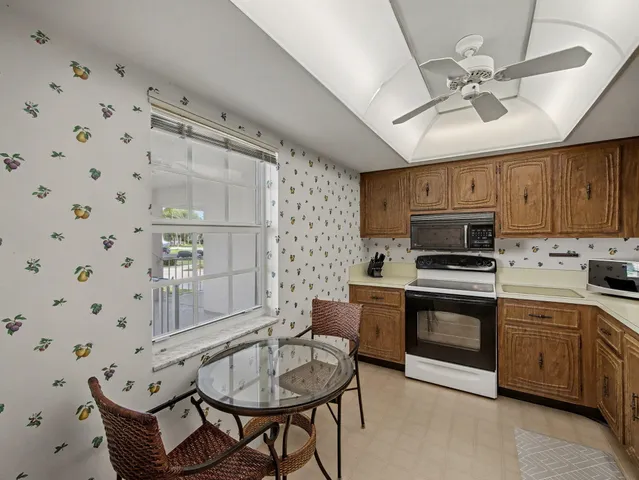 a kitchen with granite countertop a sink cabinets stainless steel appliances and a chandelier