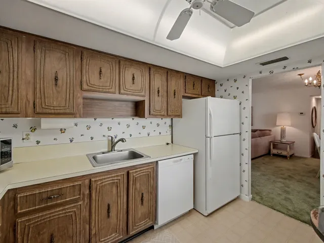 a kitchen with sink a refrigerator and cabinets
