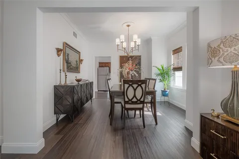 a dining room with furniture a chandelier and wooden floor