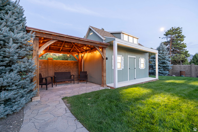 687 South 2080th Street East Springville, UT 84663 - Photo 145 of 149 Backyard featuring a stone-paved patio with a wooden pergola, an adjacent shed with a front porch, and a manicured lawn