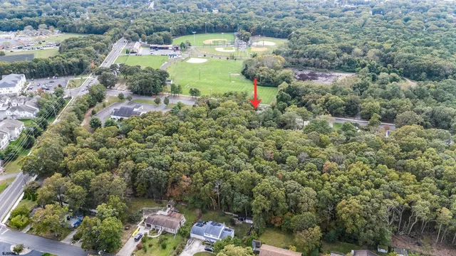 an aerial view of residential house with outdoor space and trees all around