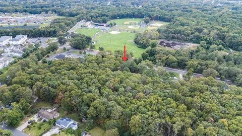an aerial view of residential houses with outdoor space and trees