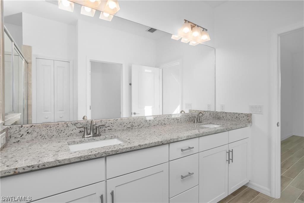 1395 Birdie Drive Naples, FL 34120 - Photo 11 of 17 a bathroom with a double vanity sink and a mirror
