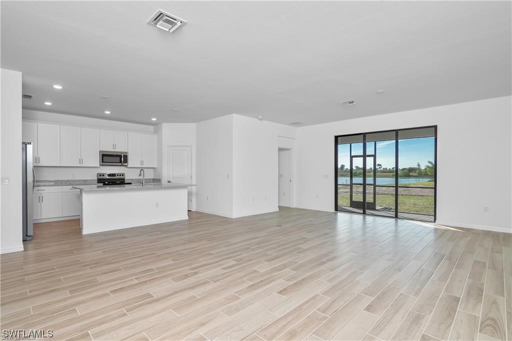 1395 Birdie Drive Naples, FL 34120 - Photo 16 of 17 a view of kitchen with wooden floor and electronic appliances