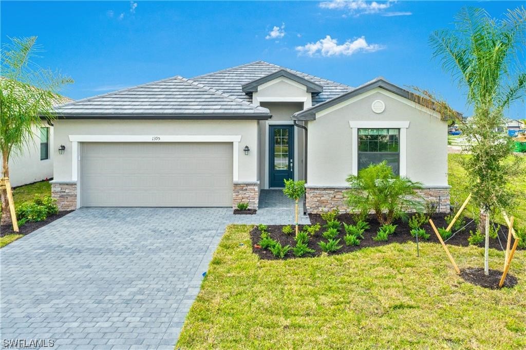 1395 Birdie Drive Naples, FL 34120 - Photo 3 of 17 a front view of a house with a yard and garage