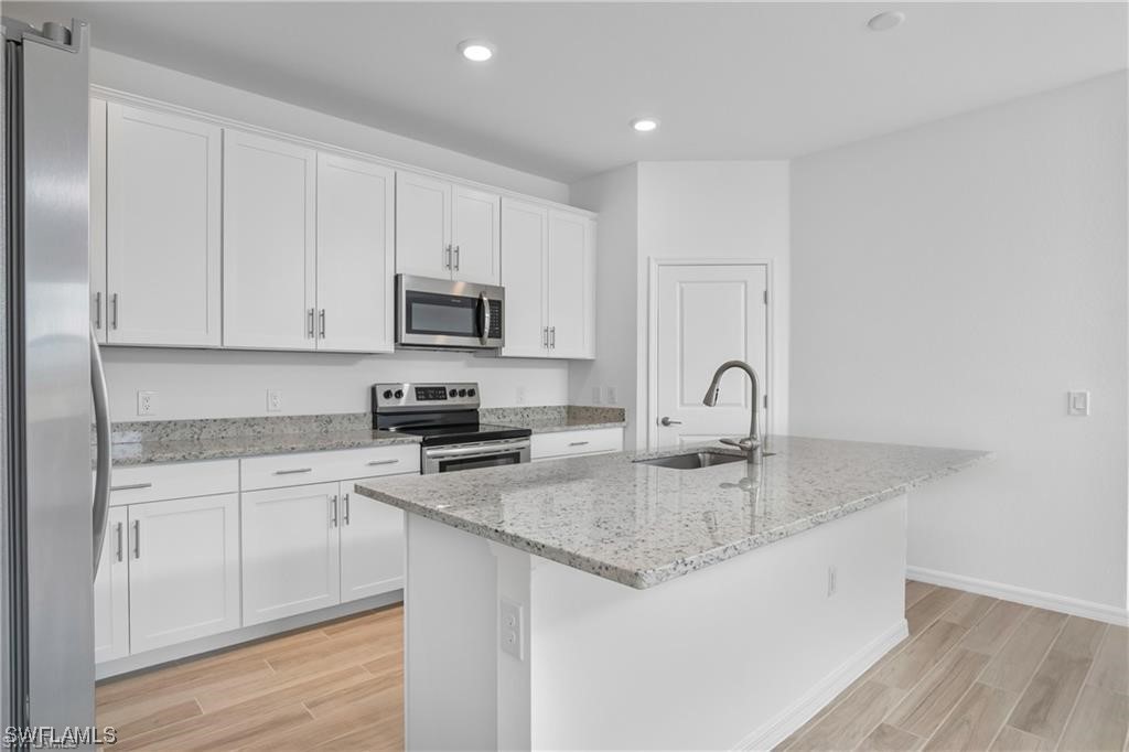 1395 Birdie Drive Naples, FL 34120 - Photo 8 of 17 a kitchen with granite countertop white cabinets and a sink