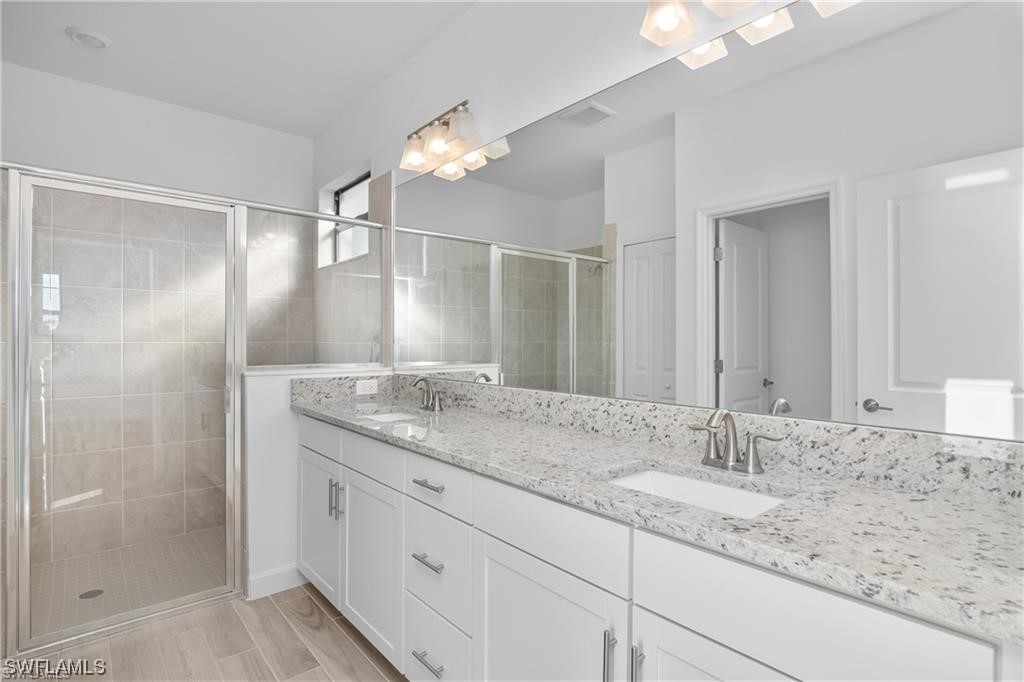 1395 Birdie Drive Naples, FL 34120 - Photo 10 of 17 a bathroom with a granite countertop sink and a mirror