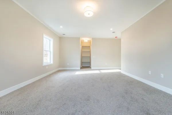 an empty room with windows and closet