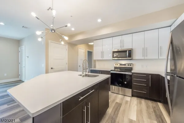 a kitchen with kitchen island a sink appliances and cabinets