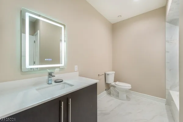 a bathroom with a sink a toilet and mirror