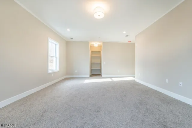 an empty room with windows and closet