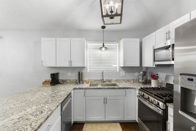 664 East Springhill Drive Washington, UT 84780 - Photo 5 of 21 U-shaped kitchen featuring white cabinetry, light-toned granite countertops, and stainless steel appliances
