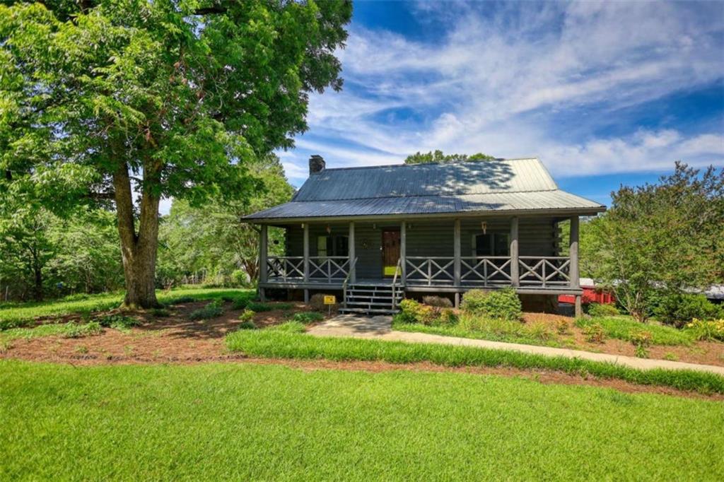 a view of house with outdoor seating and yard