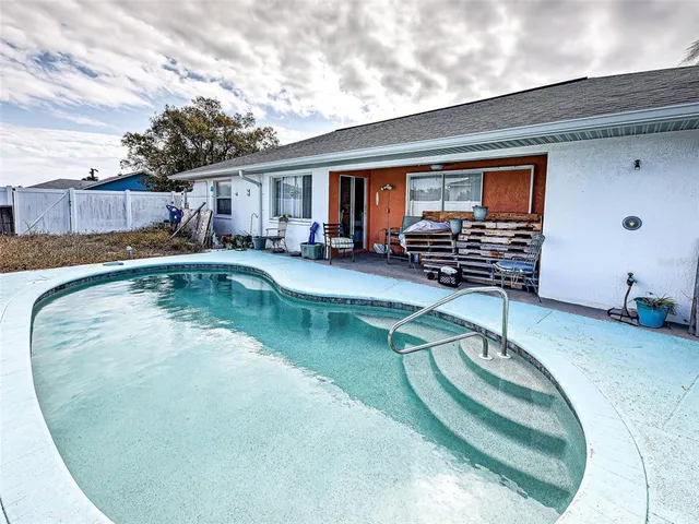 a swimming pool with outdoor seating and yard