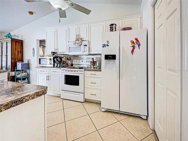 a kitchen with cabinets and chairs