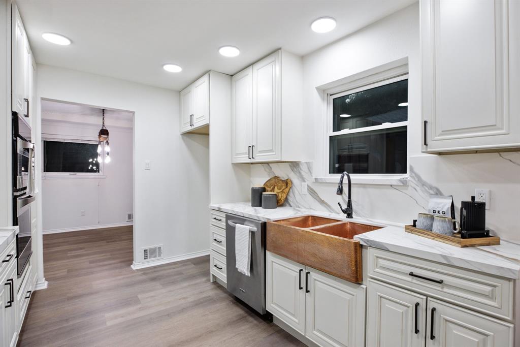 10922 Ferndale Road Dallas, TX 75238 - Photo 13 of 32 Kitchen with white cabinets, light stone countertops, light wood-type flooring, appliances with stainless steel finishes, and pendant lighting