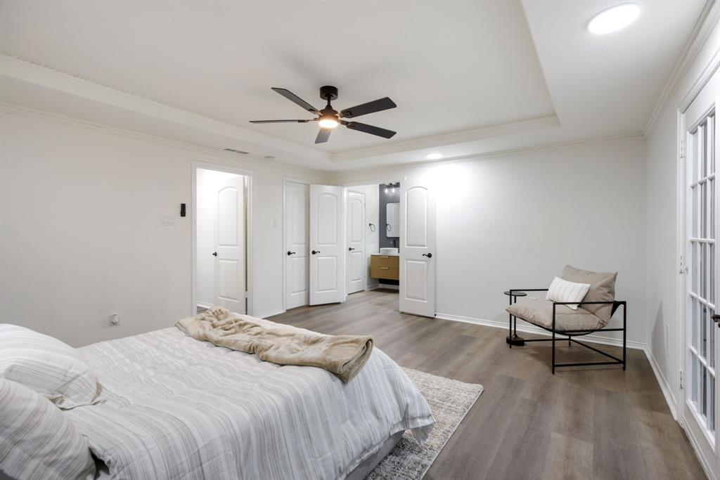 10922 Ferndale Road Dallas, TX 75238 - Photo 21 of 32 Bedroom with a raised ceiling, wood finished floors, crown molding, a ceiling fan, and ensuite bathroom
