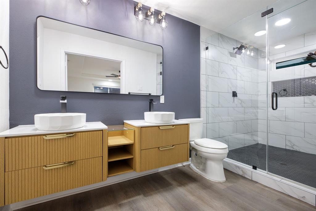 10922 Ferndale Road Dallas, TX 75238 - Photo 22 of 32 Full bathroom with a shower stall, wood finished floors, double vanity, and recessed lighting