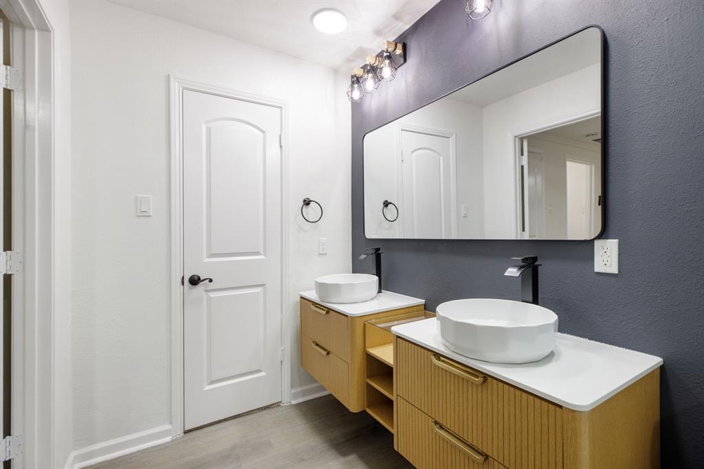10922 Ferndale Road Dallas, TX 75238 - Photo 23 of 32 Full bath with two vanities, light wood finished floors, and a textured wall