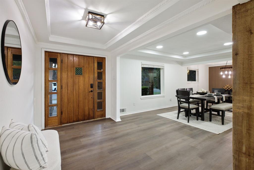 10922 Ferndale Road Dallas, TX 75238 - Photo 5 of 32 Foyer entrance featuring a tray ceiling, wood finished floors, a chandelier, ornamental molding, and recessed lighting