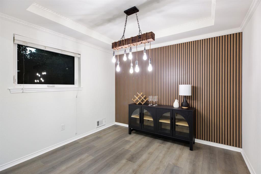 10922 Ferndale Road Dallas, TX 75238 - Photo 8 of 32 Dining room featuring a raised ceiling, wood finished floors, and crown molding