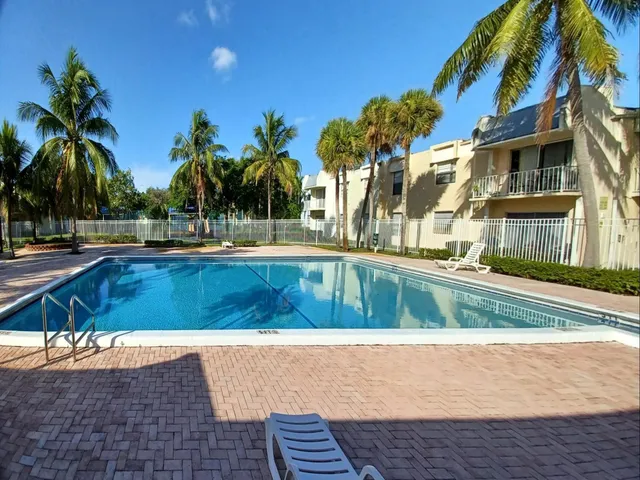 a view of swimming pool with palm trees