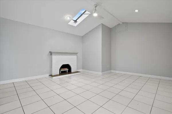 an empty room with windows and fireplace