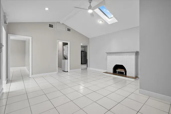 an empty room with windows and fireplace