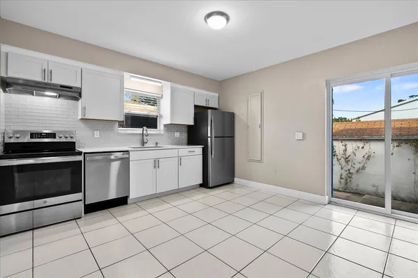 a kitchen with a sink a refrigerator and cabinets