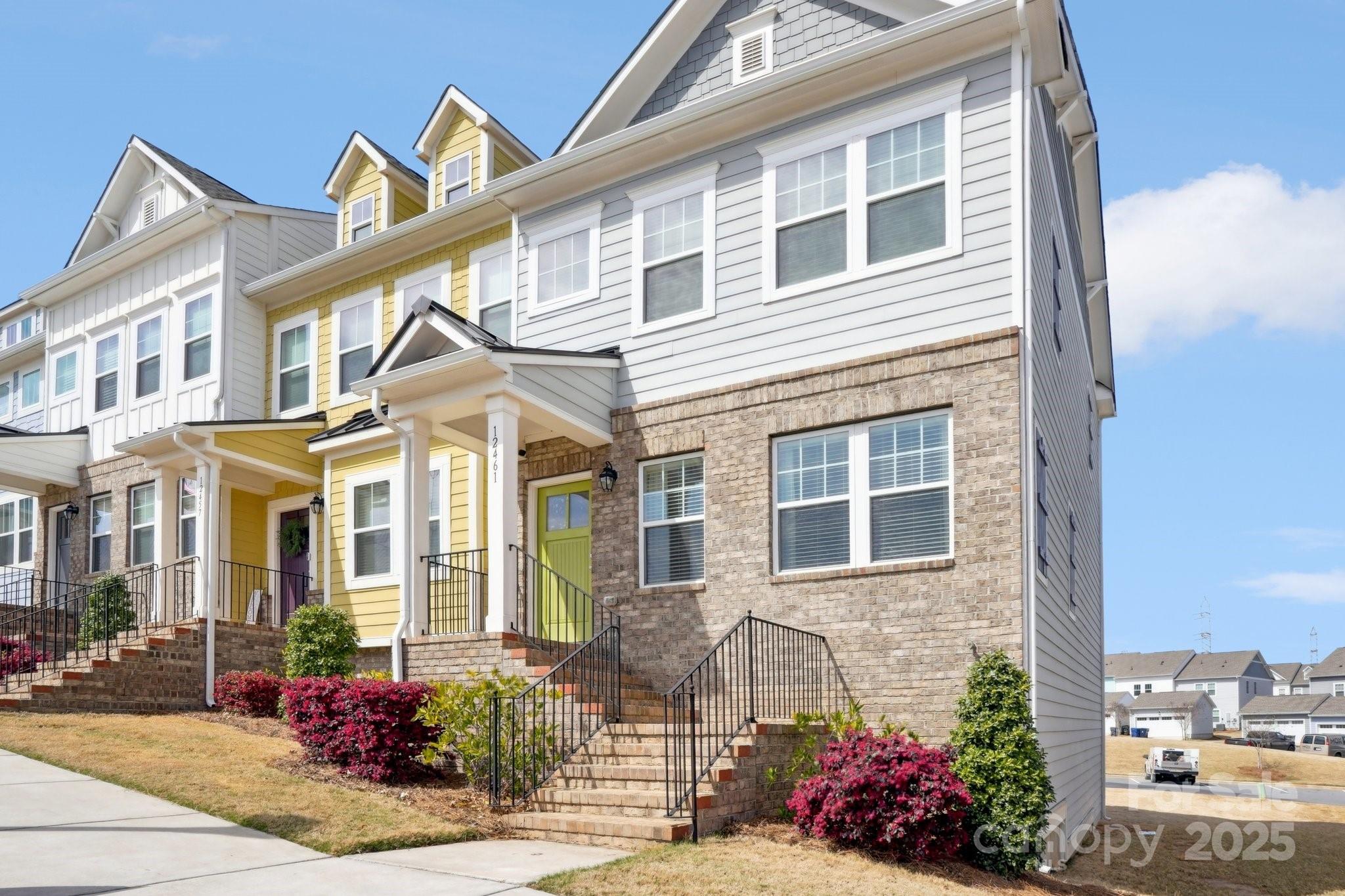 a front view of a multi story residential apartment building with yard and outdoor seating