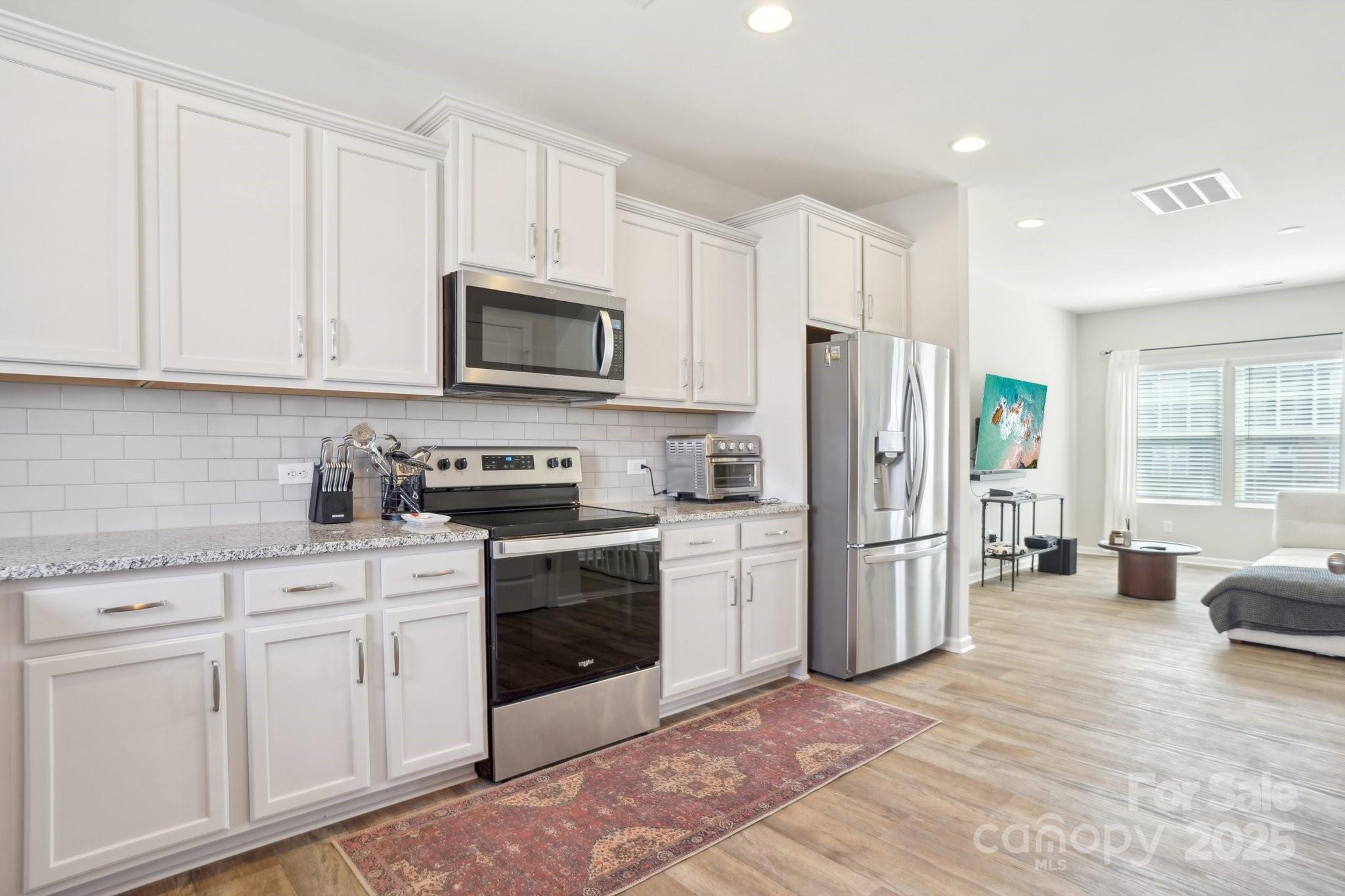12461 Bryton Ridge Parkway Huntersville, NC 28078 - Photo 11 of 33 a kitchen with stainless steel appliances granite countertop a refrigerator stove microwave and sink